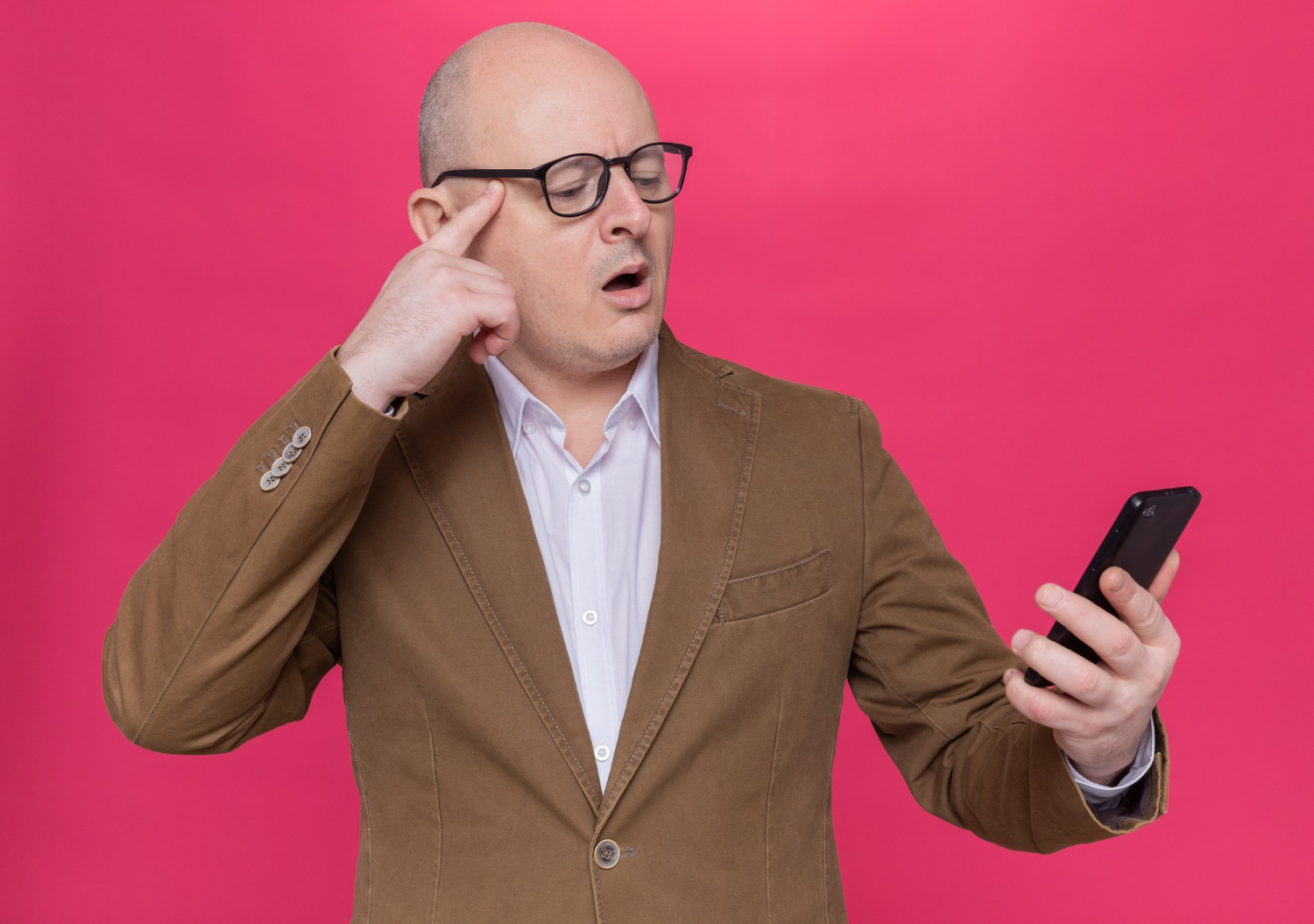 A shocked man holding a phone | Source: Freepik