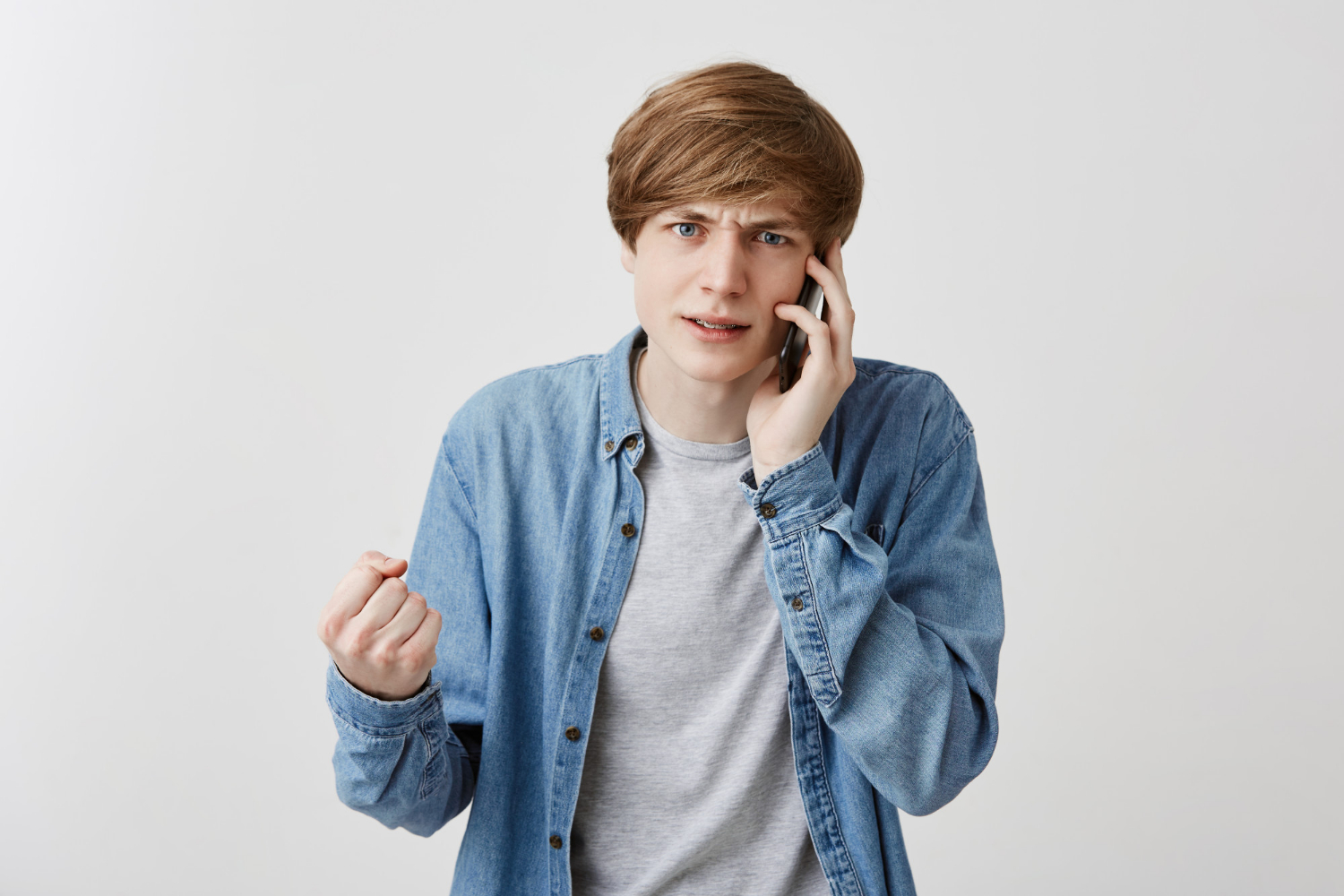 A frantic young man speaking on the phone | Source: Freepik