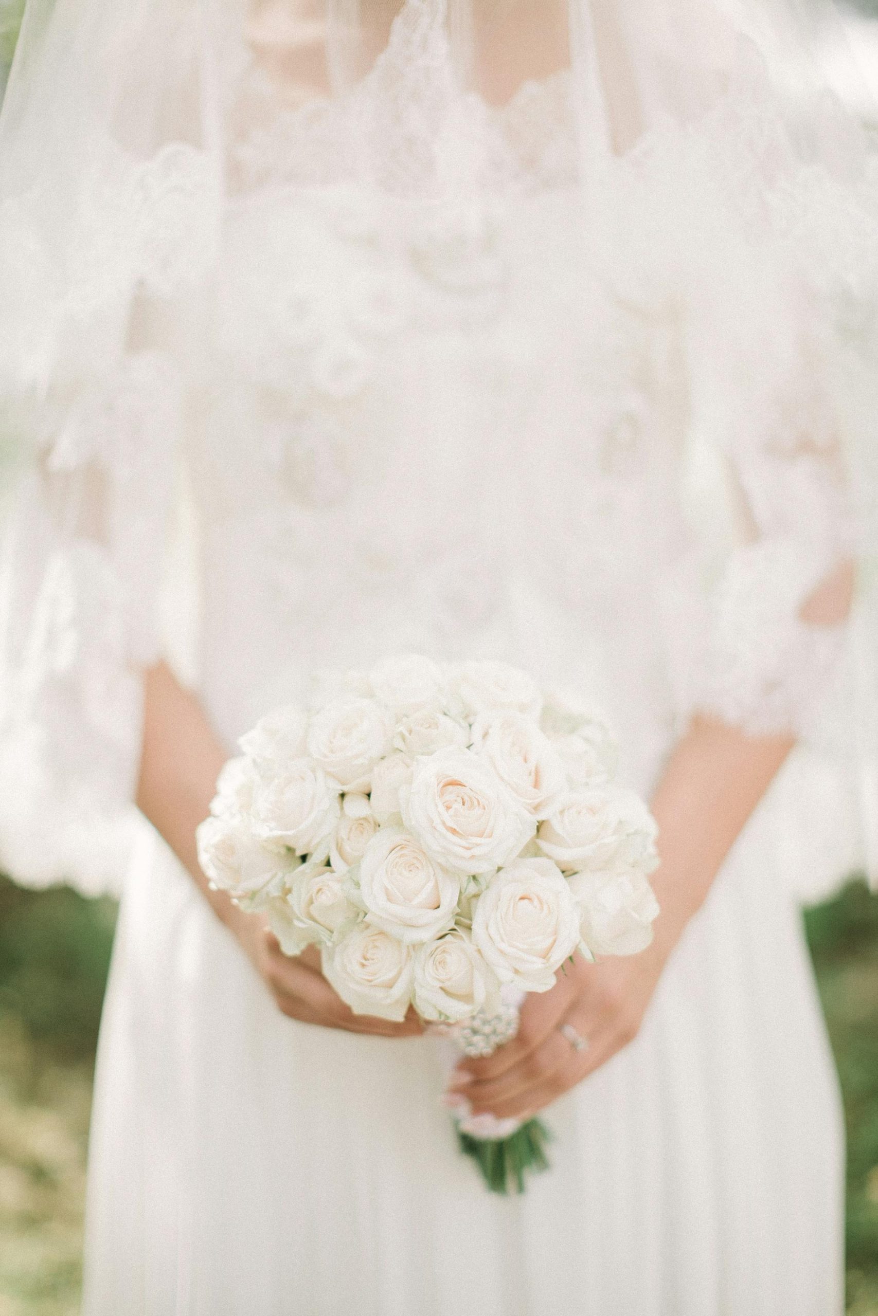A bride holding a bouquet of white roses | Source: Pexels