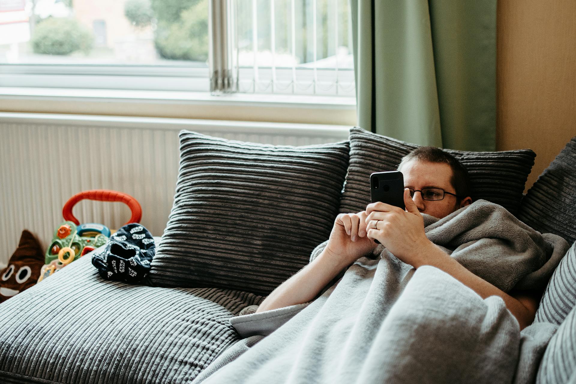 A man lying on the couch using his phone | Source: Pexels