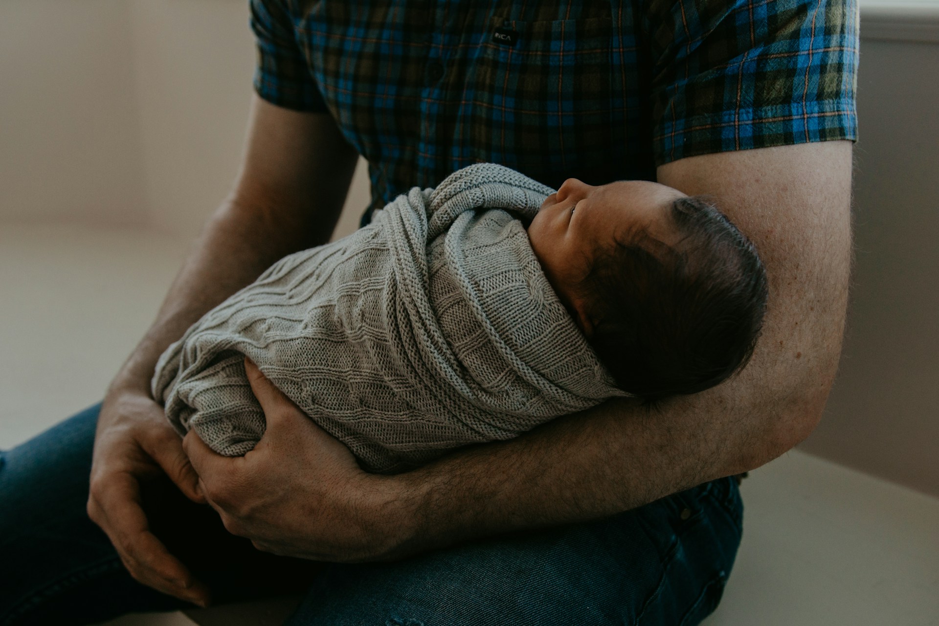 A man holding a newborn | Source: Unsplash